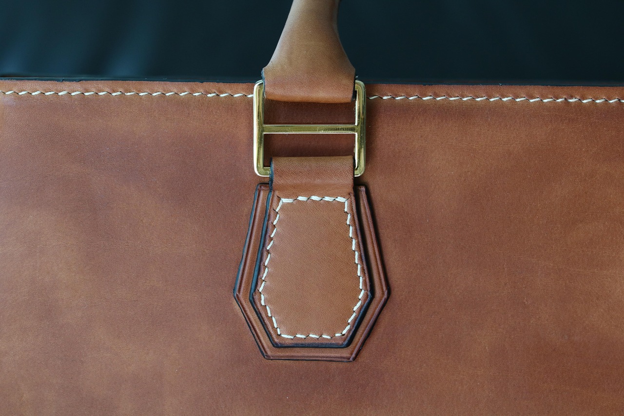 A close-up of the metal golden tri-glide slide on a bag
