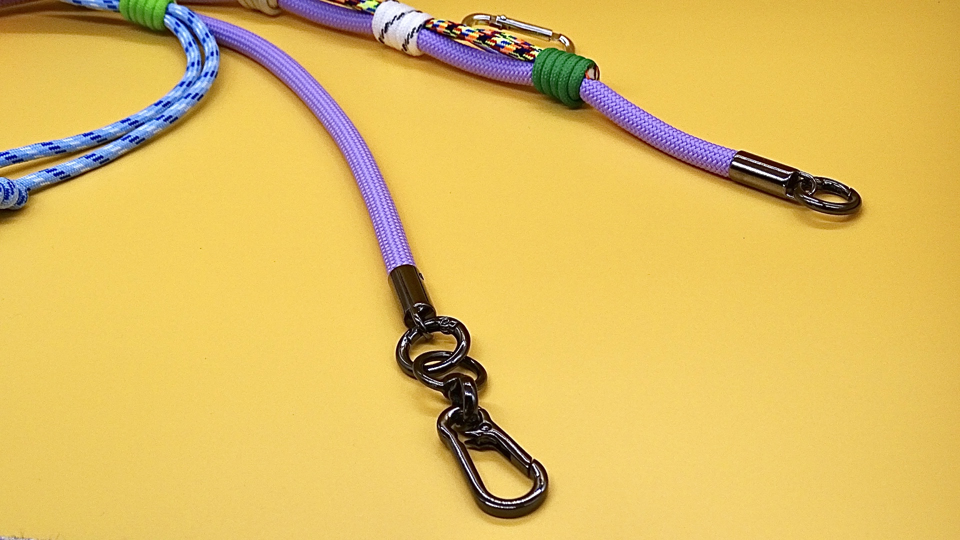 Purple phone strap with metal hooks on a yellow surface
